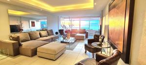 a living room with a couch and a table at Penthouse en Las Brisas Acapulco in Acapulco