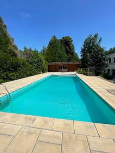 a blue swimming pool with a wooden deck and a building at appartement avec terrasse in Sillery