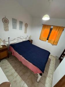 a bedroom with a bed with a blue comforter at Casa de verano Marcos Lopez in Villa Cura Brochero