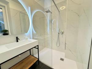 a white bathroom with a sink and a shower at Boutique Apartment Trieste in Trieste +13 photos