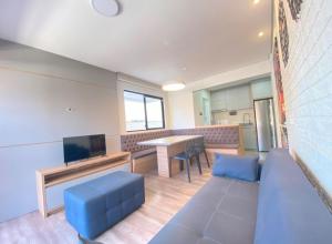 a living room with a blue couch and a table at Apto mobiliado em Balneário Piçarras 100 m do mar in Piçarras