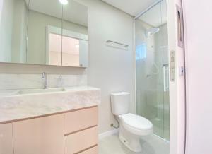a bathroom with a toilet and a glass shower at Apto mobiliado em Balneário Piçarras 100 m do mar in Piçarras +14 photos