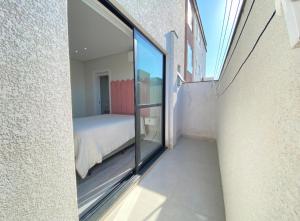 a room with a bed and a glass wall at Apto mobiliado em Balneário Piçarras 100 m do mar in Piçarras