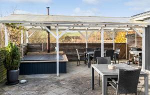 un patio con mesas y sillas bajo una pérgola en Cozy Home In Haderslev With Wifi, en Haderslev