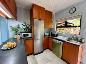 a kitchen with a stainless steel refrigerator and a sink at Berg Escape Poplar - Spacious Family Home in Bergview +32 photos