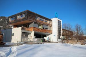 un edificio en la nieve delante en Appartements Waluliso by Schladming-Appartements, en Schladming