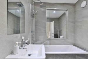 a white bathroom with a tub and a sink at Newly Extended 3 Bed Family Home Near Graves Park in Sheffield +37 photos