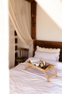 a bed with a tray with two bowls on it at Sadova Village - Casa Maria in Sadova