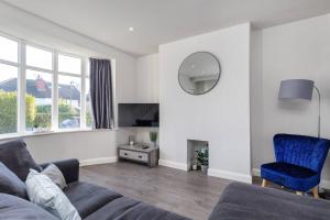 a living room with a couch and a mirror at Newly Extended 3 Bed Family Home Near Graves Park in Sheffield