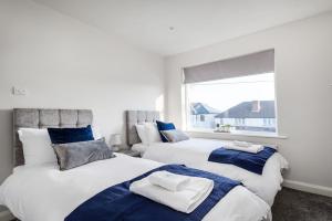 two beds in a room with a window at Newly Extended 3 Bed Family Home Near Graves Park in Sheffield