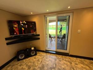 a room with a tv and speakers and a balcony at Casa Sítio Caminhos Da Serra in Feliz