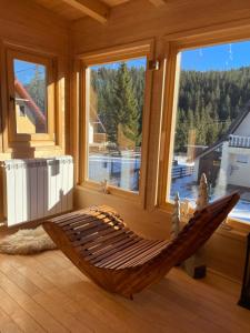 a hammock sitting in a room with windows at Alpha Ski Apartmani in Jahorina