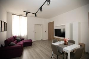 a living room with a table and a purple couch at Casa in Centro in Ascoli Piceno