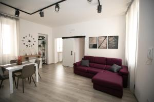 a living room with a purple couch and a table at Casa in Centro in Ascoli Piceno