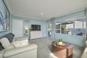 a living room with a couch and a table at Cosy Private Home in South Bay in Kaikoura