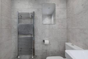 a bathroom with a toilet and a towel rack at Prime Location, Modern 2br House in Sheffield +60 photos