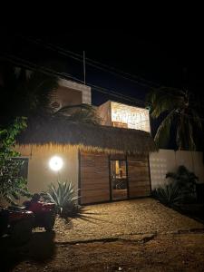 un edificio con tetto di paglia di notte di Dada Hotel a Brisas de Zicatela
