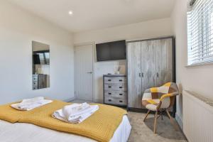 a bedroom with a bed with a yellow blanket and a chair at Modern, Cosy Whole House Wifi Close To Attractions in Sheffield