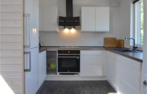 a kitchen with white cabinets and a black oven at Three-Bedroom Holiday Home In Ebeltoft in Ebeltoft