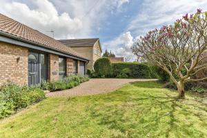 a house with a yard with a tree and a building at 3 Br Bungalow Close To Peak District With Garden in Sheffield