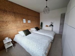 two beds in a bedroom with a brick wall at Charmante maison familiale in Rixheim