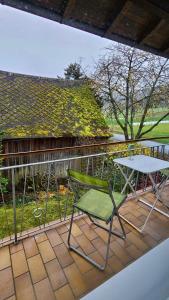 a green chair and a table on a balcony at Ferien-und Monteurwohnung 'Friedersdorfer Mühle' in Pressig
