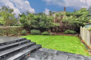 a backyard with a yard with stairs and a yard sidx sidx sidx at 3 Bed Refurbished, Modern House, Wifi, Patio Area in Sheffield