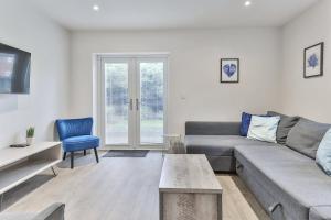 a living room with a gray couch and a blue chair at 3 Bed Refurbished, Modern House, Wifi, Patio Area in Sheffield