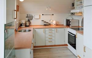 a kitchen with white cabinets and a sink at Holiday Home Ringkøbing With Fireplace Ii in Ringkøbing