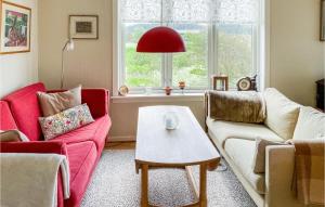 a living room with two couches and a table at Beach Front Home In Smøla With Kitchen in Smøla