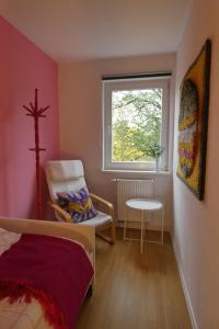 a bedroom with a bed and a window and a chair at Ferien-und Monteurwohnung 'Friedersdorfer Mühle' in Pressig
