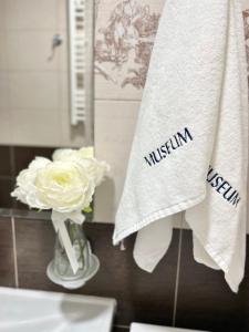 ein Badezimmer mit einer Vase mit Blumen und Handtüchern in der Unterkunft Paradise Museum City Center in Belgrad + 33 Fotos