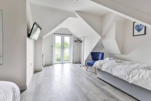 a white bedroom with a bed and a blue chair at Newly Renovated 3 Bed 2 Bath Apartment & Parking in Sheffield