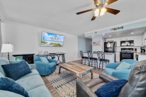 salon z niebieskimi kanapami i stołem w obiekcie Island Winds West Unit 870 w mieście Gulf Shores