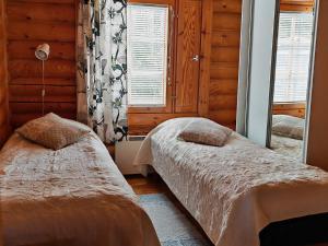 ein Schlafzimmer mit zwei Betten und einem Fenster in der Unterkunft Matikkala Cottages in Ruokolahti