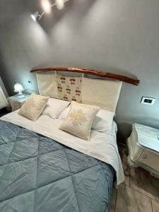 a bed with pillows on it in a room at L'attico di Giorgio in Samatzai