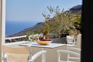 uma tigela numa mesa com cadeiras numa varanda em Anchor Suites em Oia