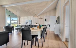 a dining room and kitchen with a table and chairs at Lovely Home In Løkken With Sauna in Løkken