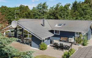 a blue house with a patio and a table at Holiday Home Bakkedraget Blåvand X in Blåvand