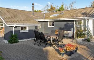 a patio with a table and chairs in front of a house at Holiday Home Bakkedraget Blåvand X in Blåvand