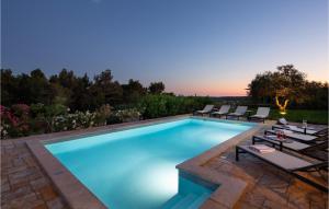 - une piscine avec des chaises longues à côté d'un complexe dans l'établissement Villa Miramonti, à Sveti Lovreč Pazenatički