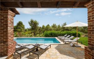 une piscine avec des chaises longues et un parasol dans l'établissement Villa Miramonti, à Sveti Lovreč Pazenatički