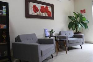 a living room with two chairs and a table at Hotel Graal Inn Queluz in Queluz +63 photos