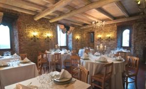 a dining room with white tables and chairs at Castello di Trisobbio in Trisobbio