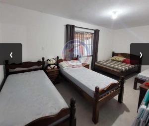 a bedroom with two beds and a couch at Casa em Mongaguá in Mongaguá