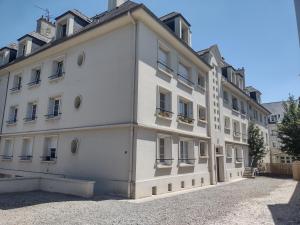 a large white building with windows at Petit appartement - Quartier Vaugueux Château in Caen
