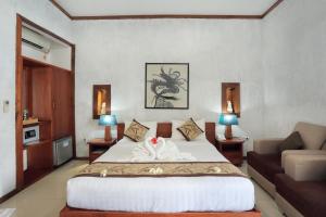 um quarto com uma cama grande e um sofá em Good Heart Resort Gili Trawangan em Gili Trawangan