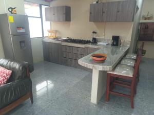 a kitchen with a counter and a table and a refrigerator at Apartamento en Cuenca in Cuenca