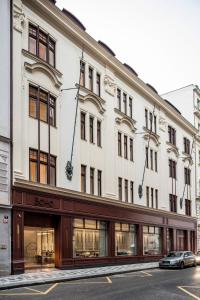 a large white building with a car parked in front of it at BoHo Prague Hotel - Small Luxury Hotels in Prague