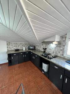 a kitchen with black cabinets and a white ceiling at Quiet Cozy Apt MQ2 & Near Beach & Mountain View in Calheta